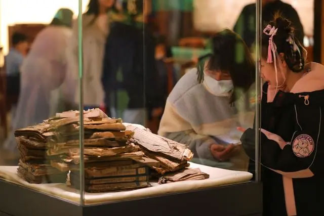 觀眾在遼寧省圖書館“古籍保護與傳承特展”中觀看未修復的破損古籍